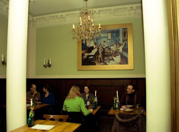 INterior de un restaurante con gente comienod en sus mesas