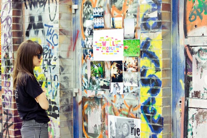 Una mujer mirando fotos colgadas en una pared