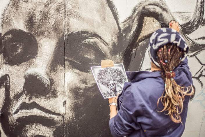 Mujer artista pintando un muro con spray