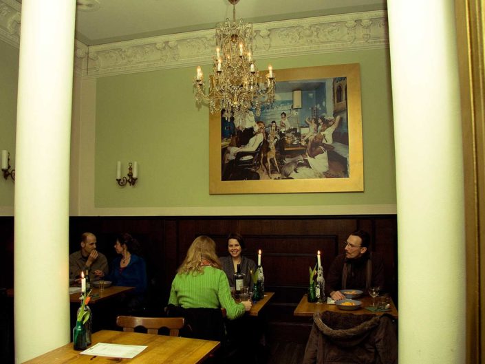 INterior de un restaurante con gente comienod en sus mesas