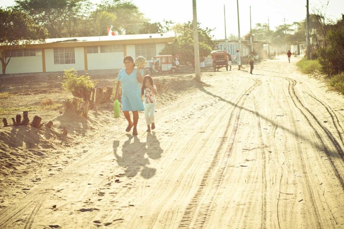 Mujer y niña andando por un camino de tierra