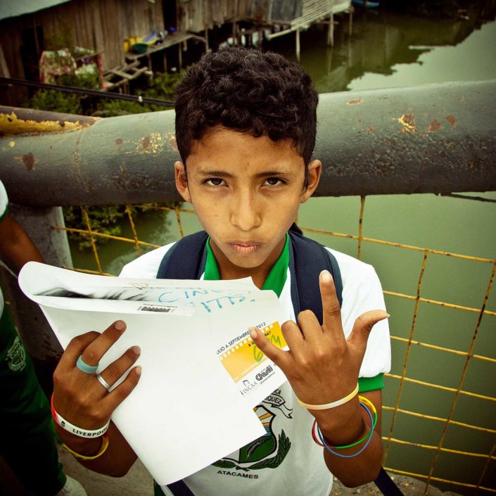Niño con papel en la mano mirabdo a la cámaar