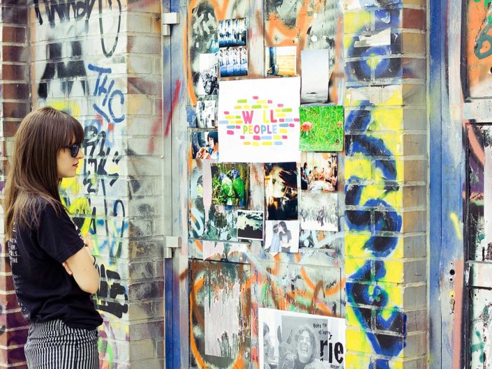 Una mujer mirando fotos colgadas en una pared